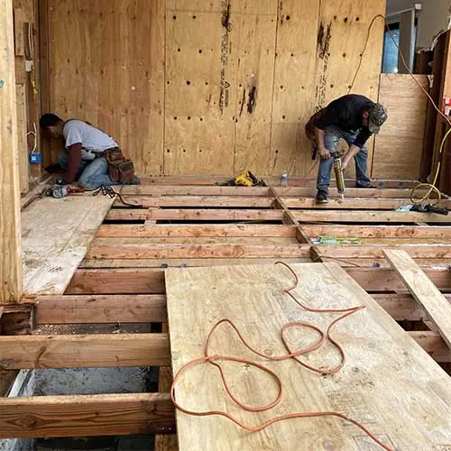 Crew installing new subfloor framing