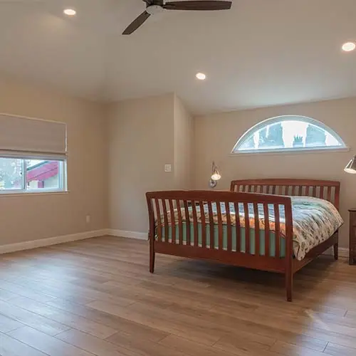Bedroom addition with an arched window and hardwood floor
