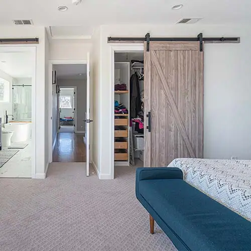 Finished bedroom addition with a barn door and walk-in closet