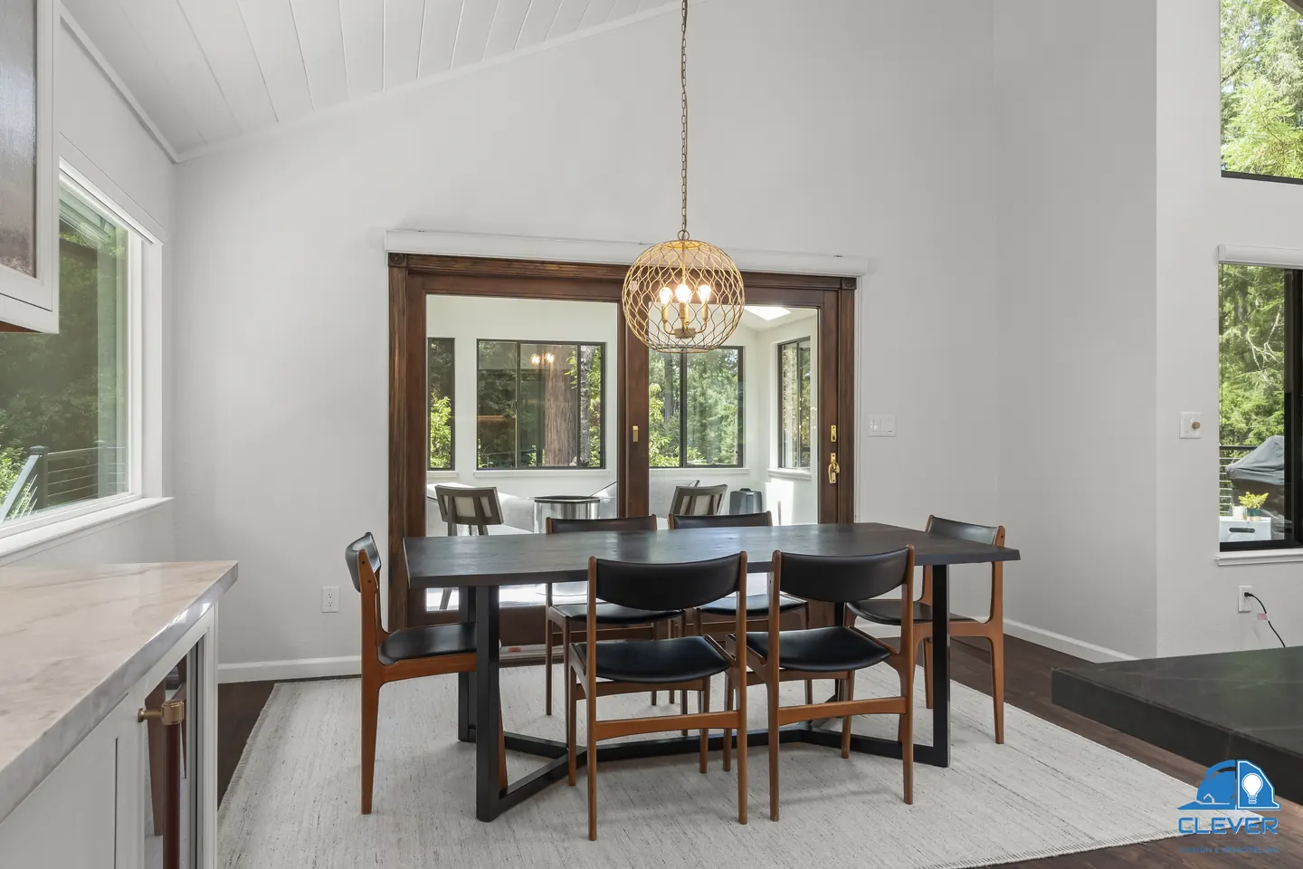 Dining nook with a black table, a brass globe pendant and wood-framed French doors, kitchen and bath remodel in Los Gatos, CA