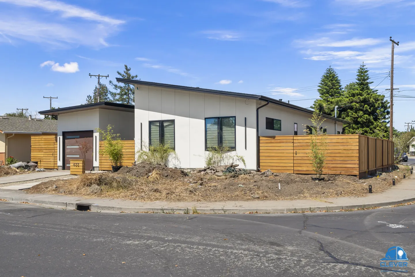 Corner view showing the shed roofs, stucco walls and the full run of cedar fence, modern home in Santa Clara, CA
