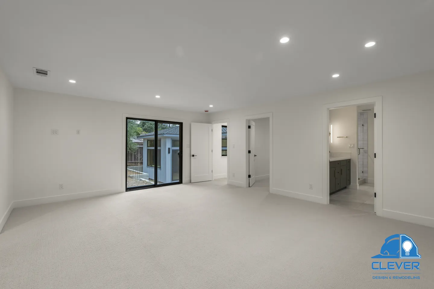Primary bedroom with a black-framed sliding door and an open door to the primary bath, whole-home remodel in Saratoga, CA