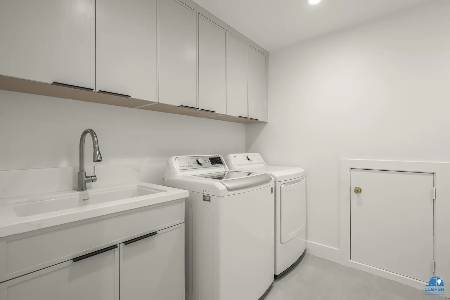 Laundry room with a utility sink, white cabinets, an oak shelf and a washer and dryer, whole-home remodel in Saratoga, CA